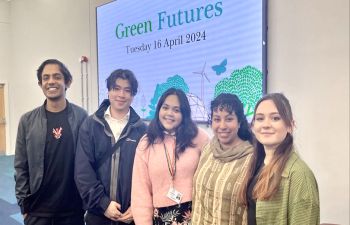 Five Ƶ alumni stand side by side in front of a large digital screen that reads 'Green Futures'