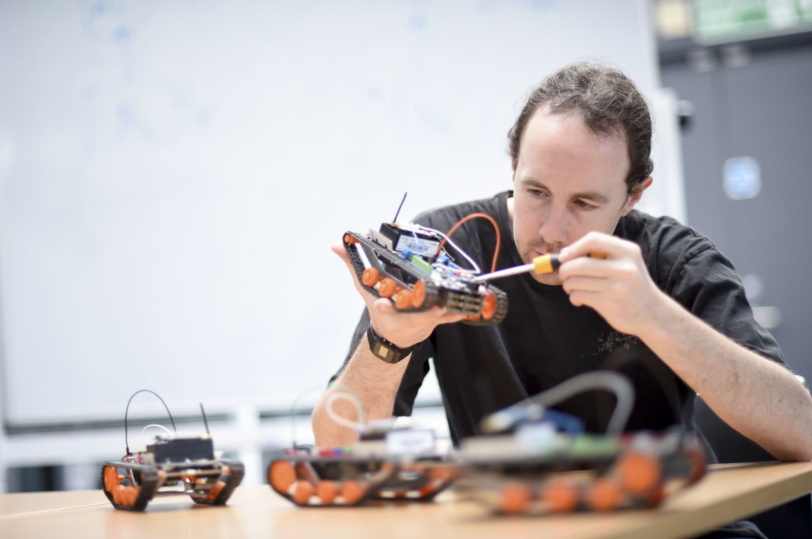 A PhD student works on mini-robots for his robotics project at the Ƶ