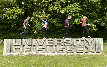Students standing on the Ƶ entrance sign