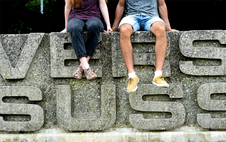 Two students sitting on the Ƶ sign