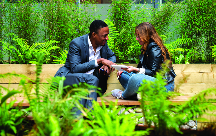 A business man and a colleague discussing a topic in a meeting in an outside space at the Ƶ